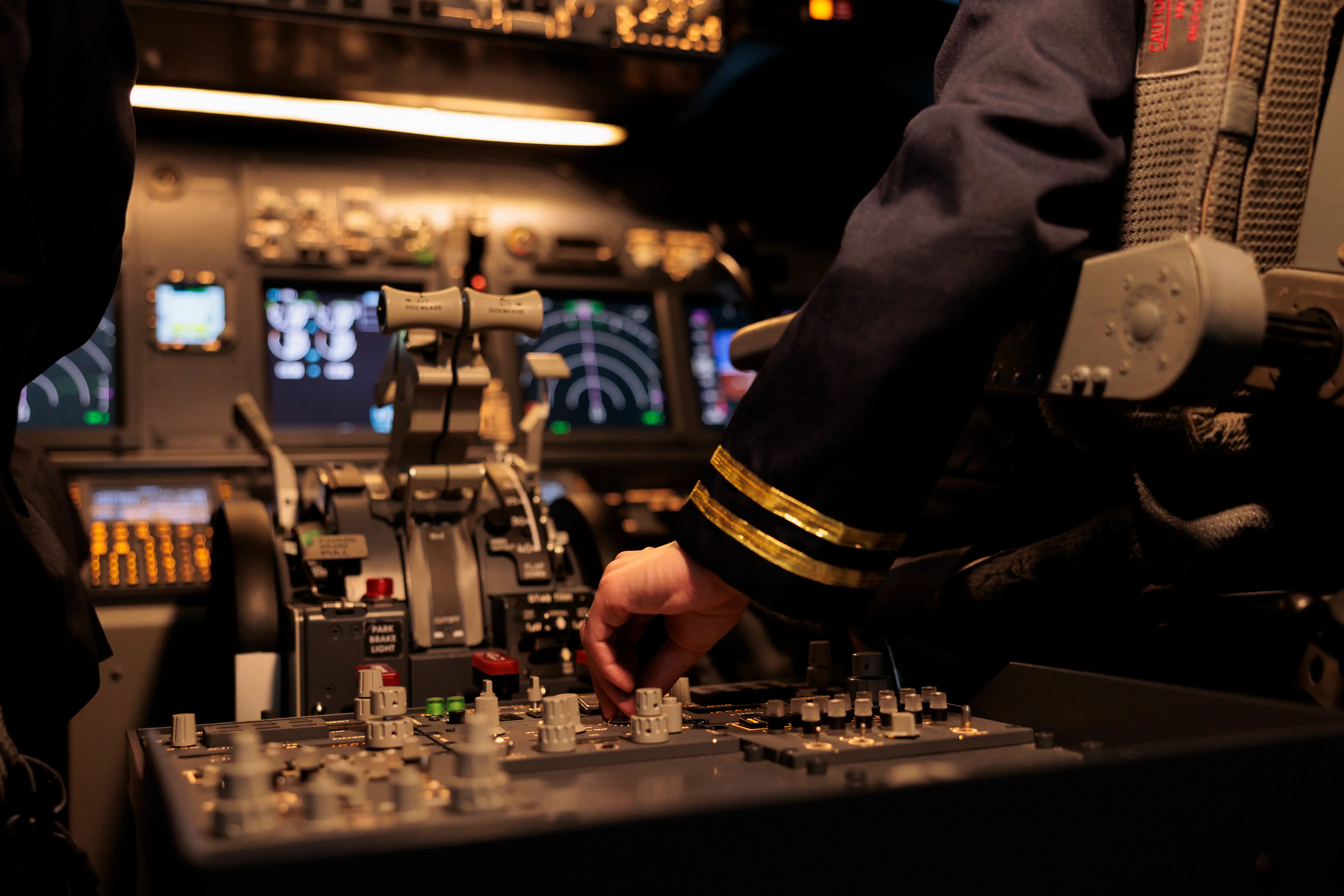 Aircrew member using control panel in airplane cockpit