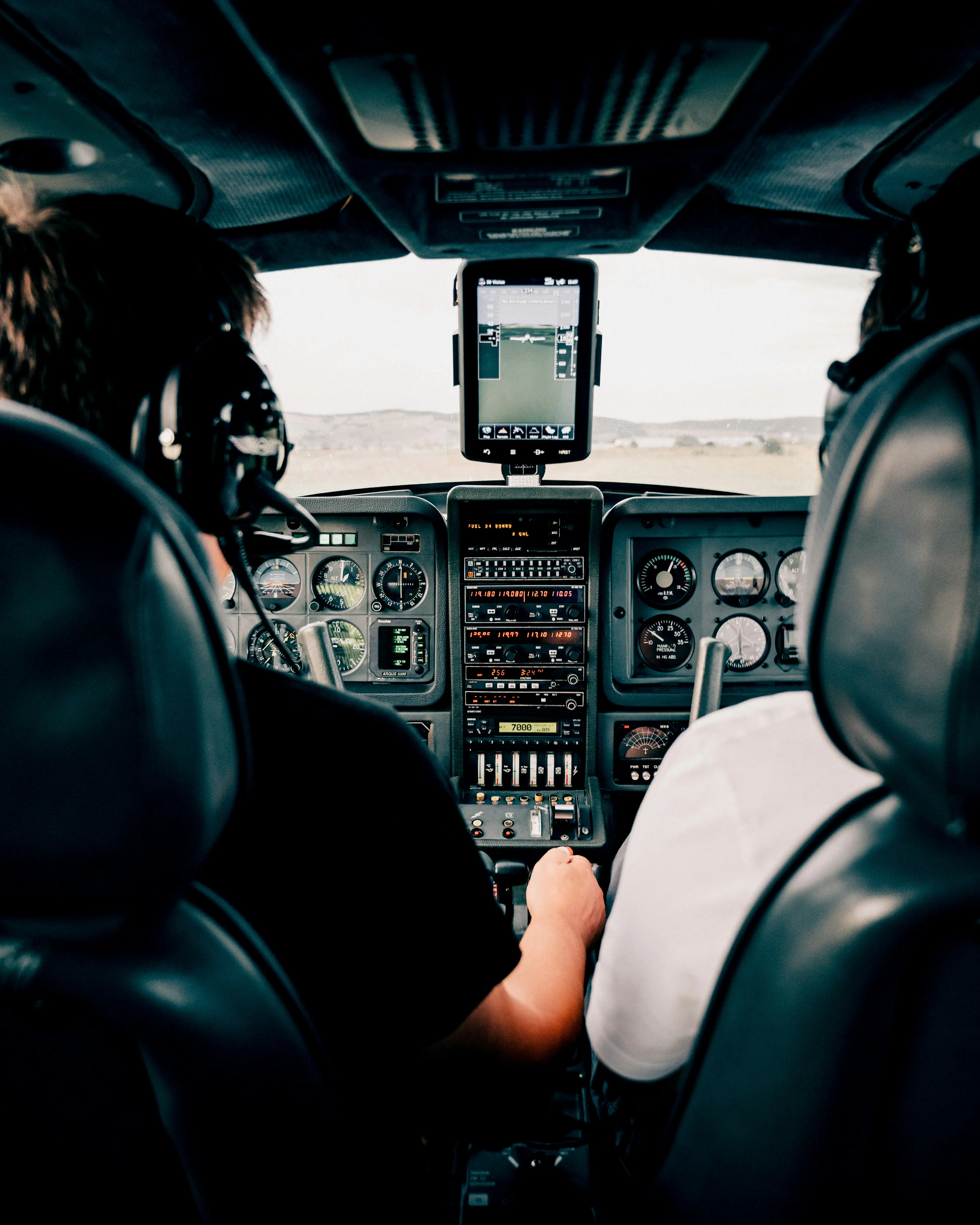 Aircrew member using control panel in airplane cockpit