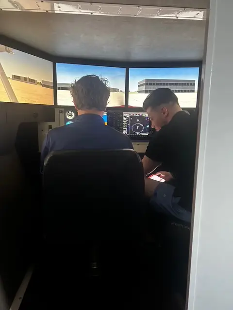 Pilot practicing instrument approaches in Redbird FMX simulator at PIC New Century KS